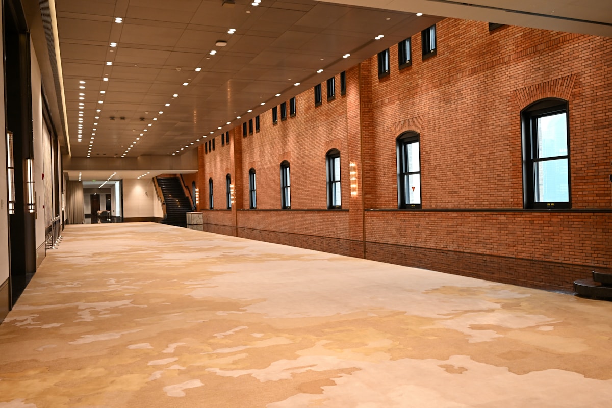 Large empty convention center exhibition hall with brick walls and patterned carpet