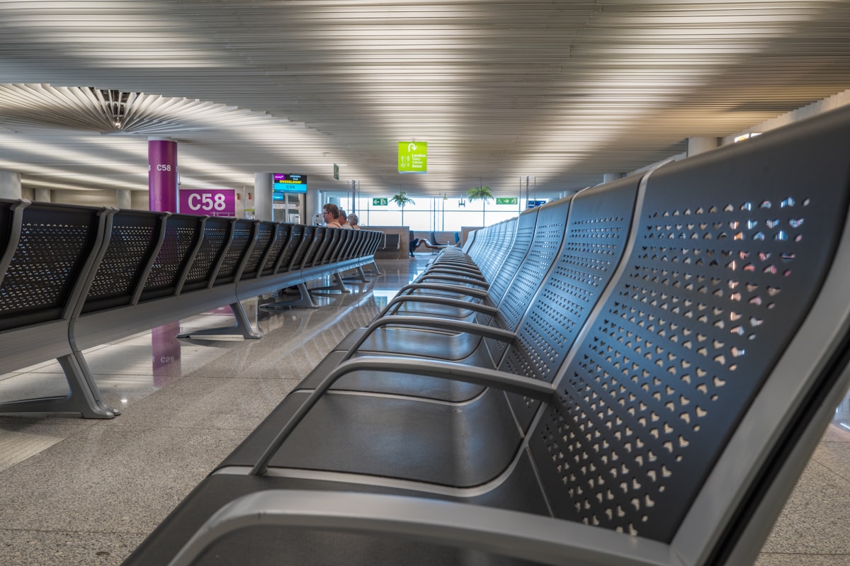 Modern airport terminal waiting area with rows of seats and natural light