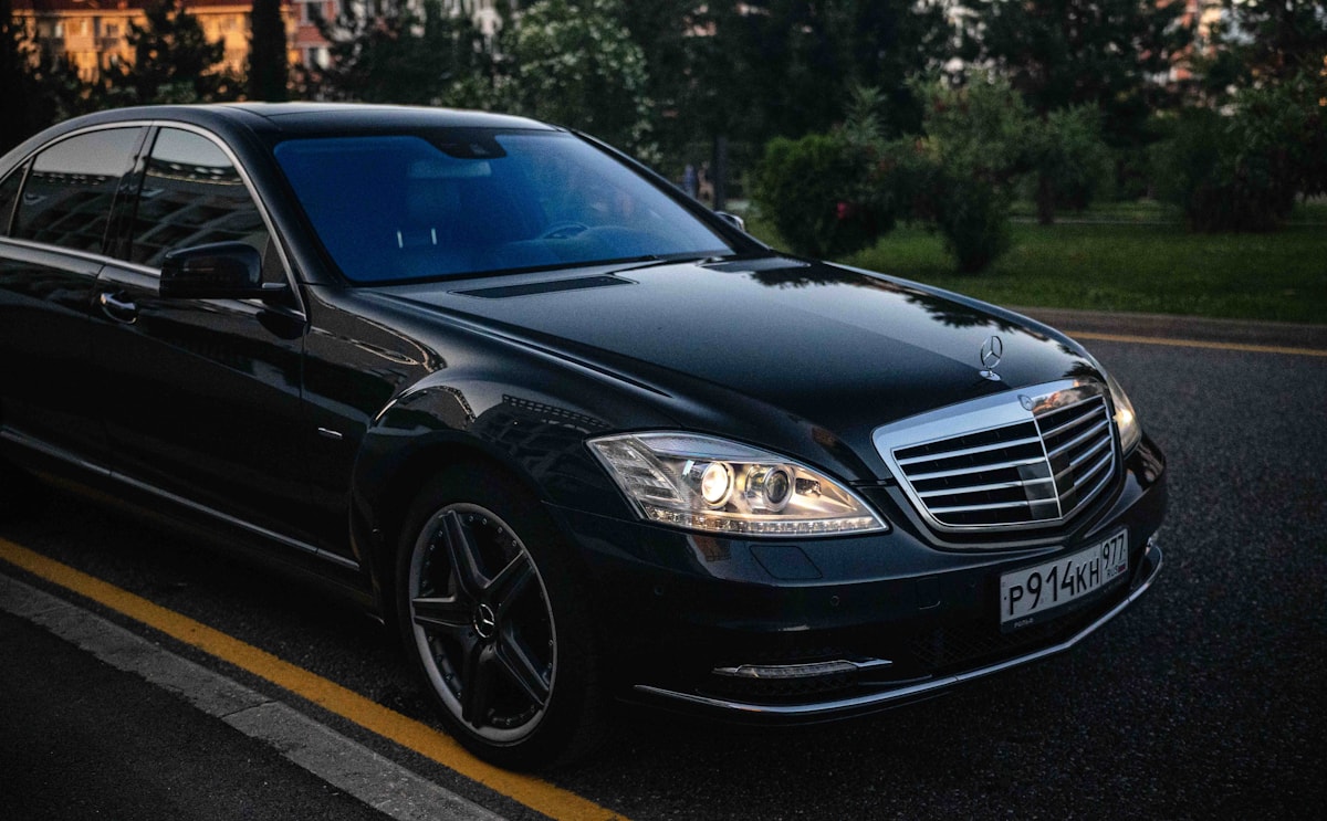 Black luxury Mercedes-Benz sedan driving on a city road